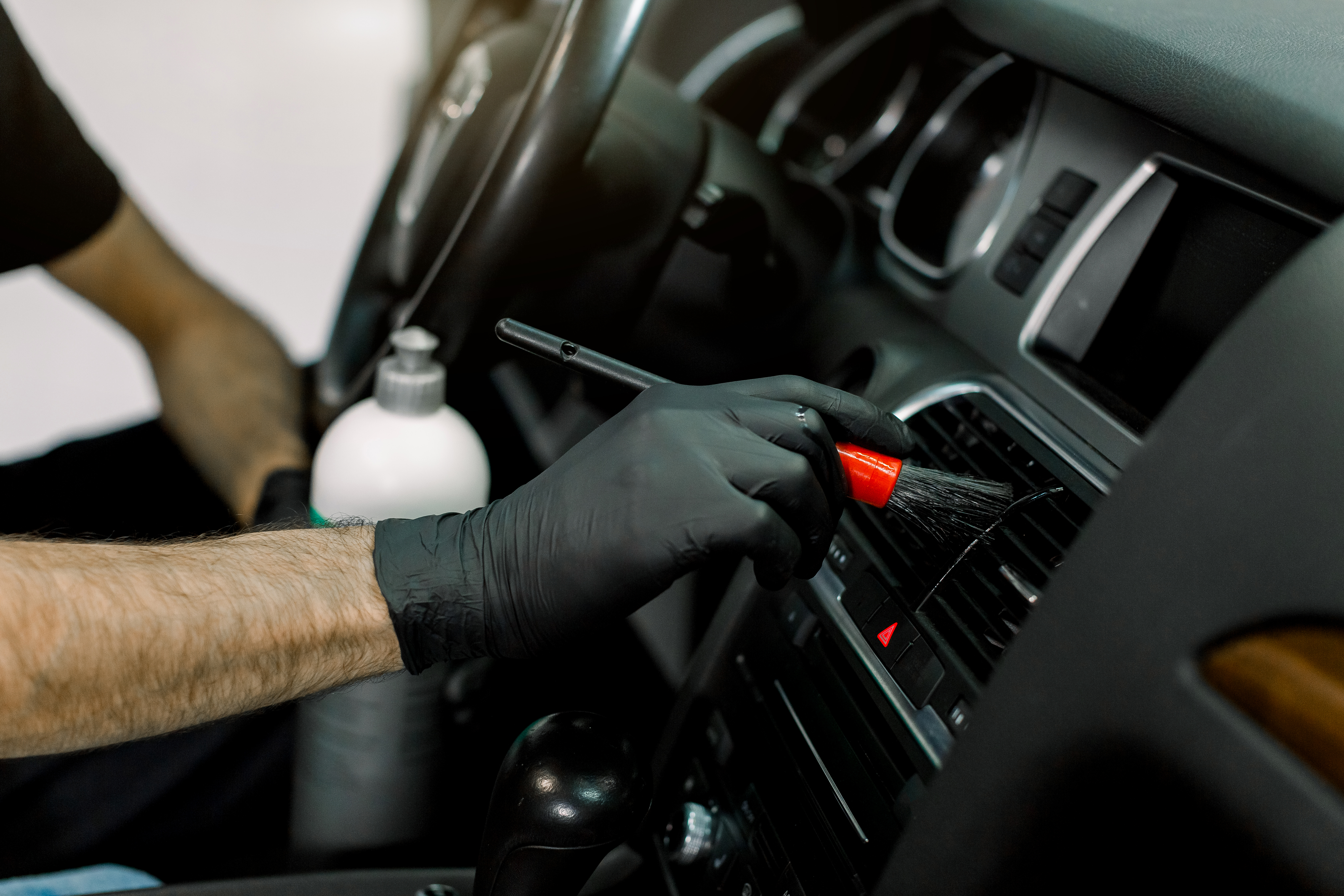 Interior Car Care, Car detailing concept. Cropped image of hands of young male worker in black